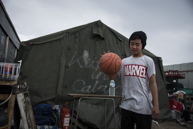 UN copil se joacă cu mingea în tabara Calais, unde locuiesc mii de migranti, va fi dărâmată