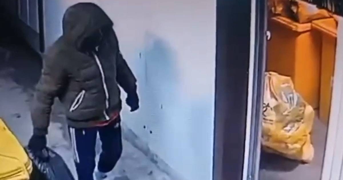 barbat cu geaca si gluga pe cap cu un sac nergu in mana, langa un tomberon galben in timp ce fura saci cu picioare amputate de la spitalul cantacuzino din bucuresti