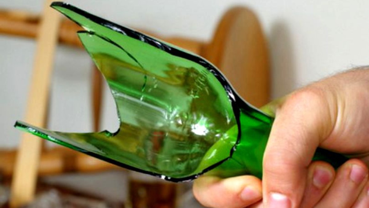 Bărbatul care și-a lovit fosta iubită cu sticla în cap. O sticlă spartă, de culoare verde, în mana unui bărbat