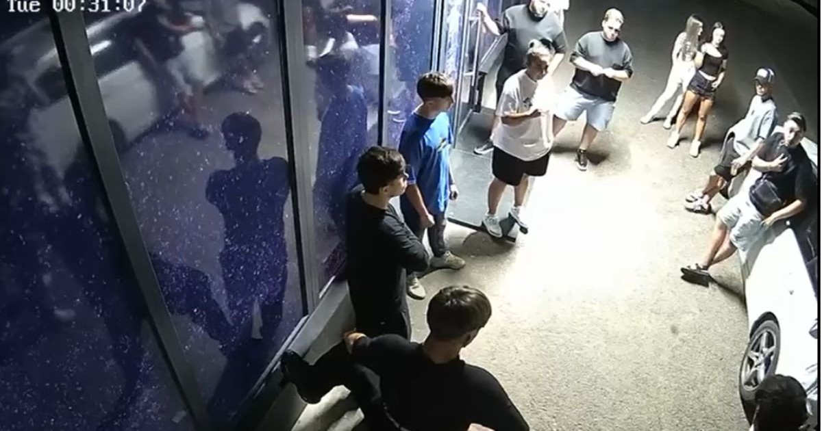Mai mulți tineri stau in cerc in fata unei cladiri