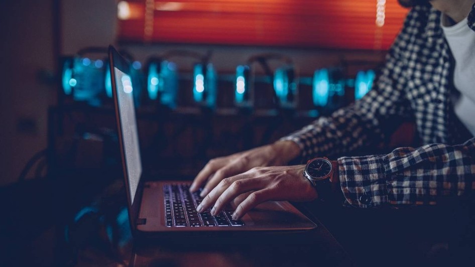IT-ist lucreaza la laptop intuneric
