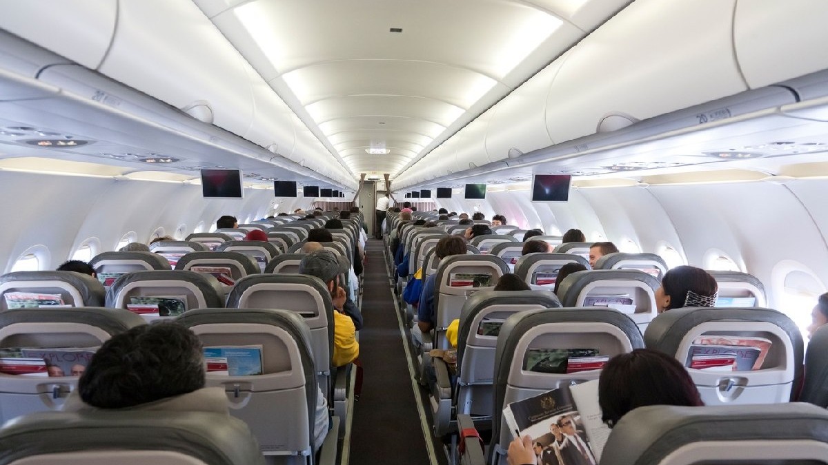 Pasageri stau pe scaune intr-un avion