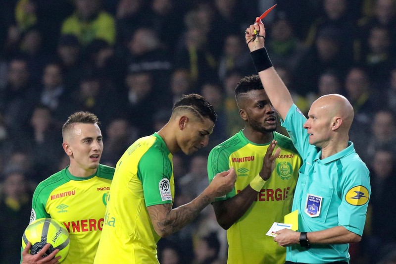 epa06440309 The referee Tony Chapron gives a red card for DIego Carlos of Nantes after he kicked him during the French League 1 soccer match between FC Nantes and Paris Saint Germain (PSG) at the Beaujoire stadium in Nantes, France, 14 January 2018. EPA-EFE/EDDY LEMAISTRE