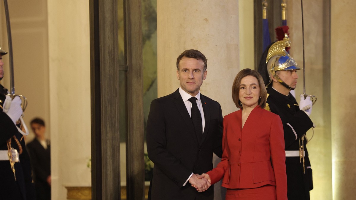 Emmanuel Macron (stânga) și Maia Sandu (dreapta) surprinși în timp ce-și strâng mâinile
