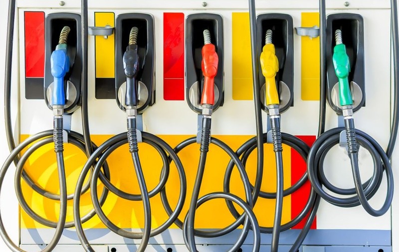 O stație de alimentare colorată, cu mai multe pistoale de diverse culori – albastru, negru, roșu, galben și verde –, fiecare reprezentând un tip diferit de combustibil. Foto: Shutterstock