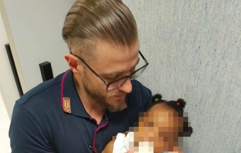 Imagine virală. Un polițist e lăudat de întreaga lume pentru că a îngrijit o fetiță, cât mama ei era la spital