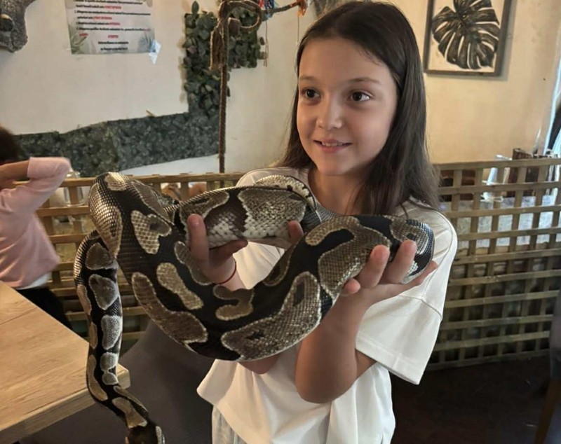 Fetița Biancăi Drăgușanu, cu șarpele în brațe de ziua ei. Mama a îndeplinit dorința copilului: „De ziua ei facem ce și-a dorit”
