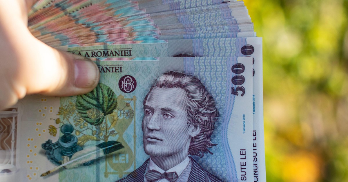 Imagine cu mai multe bancnote de 500 de lei ținute în mână de un bărbat