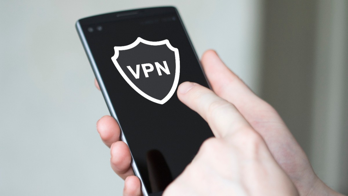 Un bărbat care ține în mână un telefon pe care scrie VPN