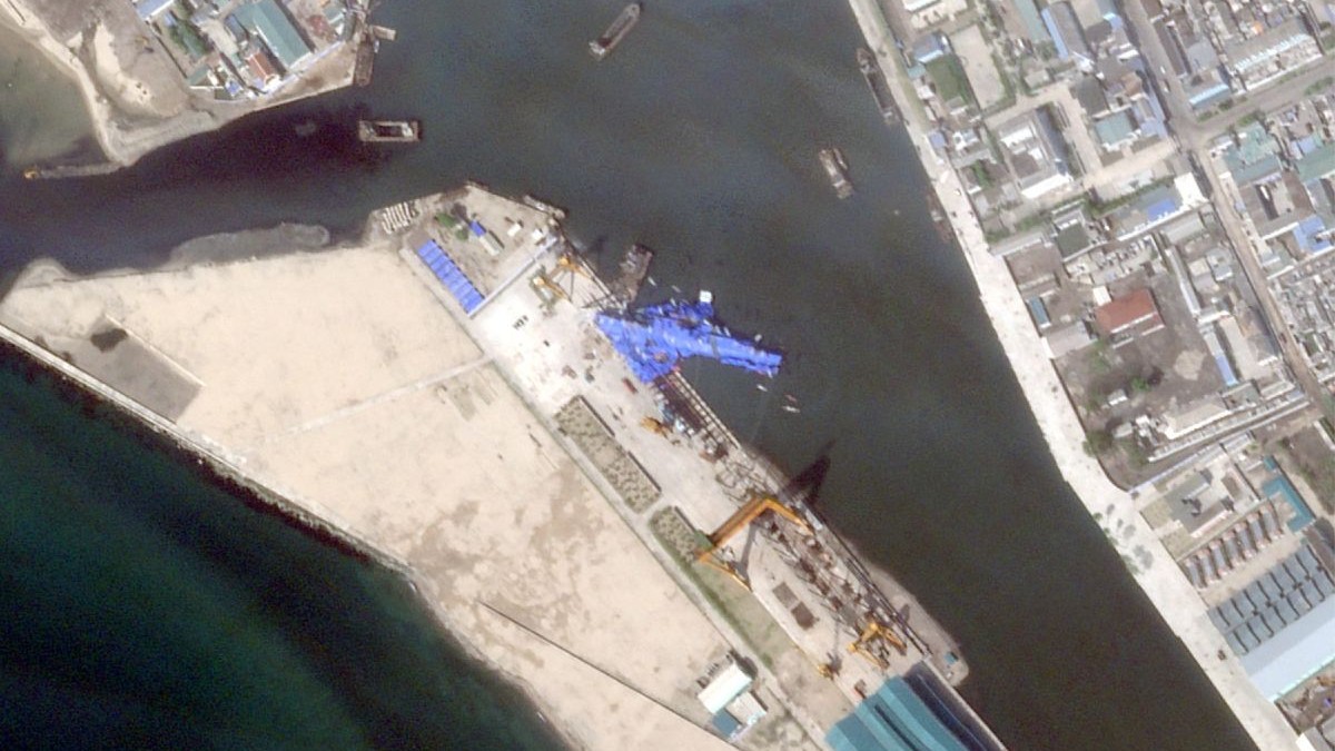 Această imagine din satelit, realizată și publicată pe 23 mai 2025 de Planet Labs PBC, arată o nouă navă de război nord-coreeană care pare să se fi răsturnat în port după ceremonia de lansare din Chongjin.