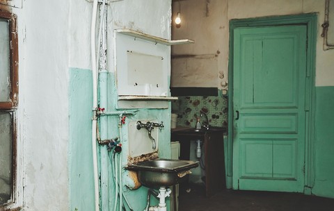 Casă sărăcăcioasă cu o ușă pictată verde mentă