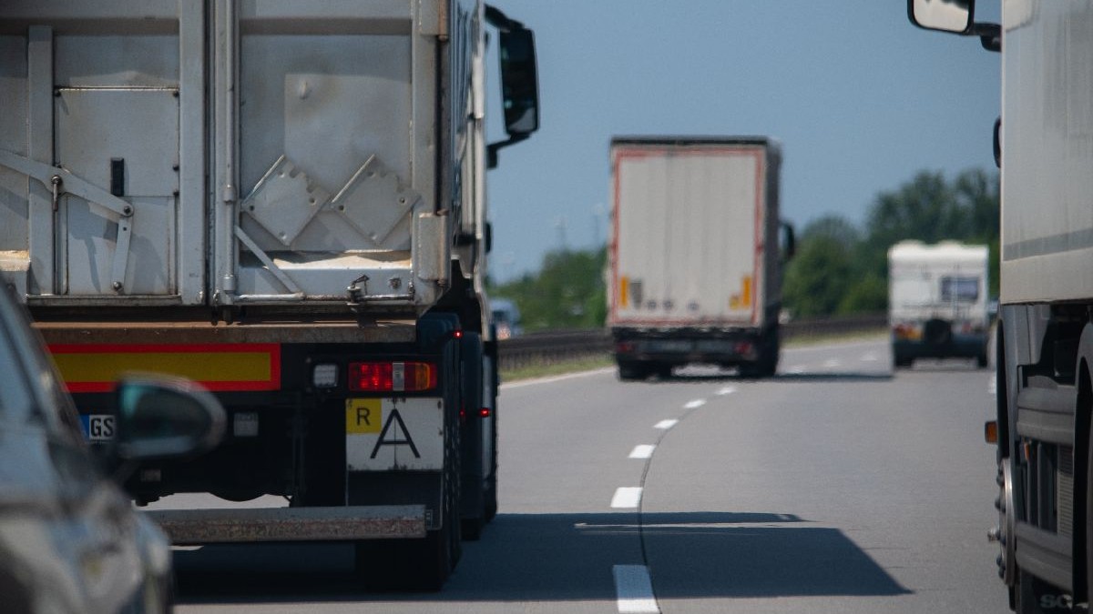 Fotografie cu o autostradă aglomerată, pe care circulă mai multe camioane.