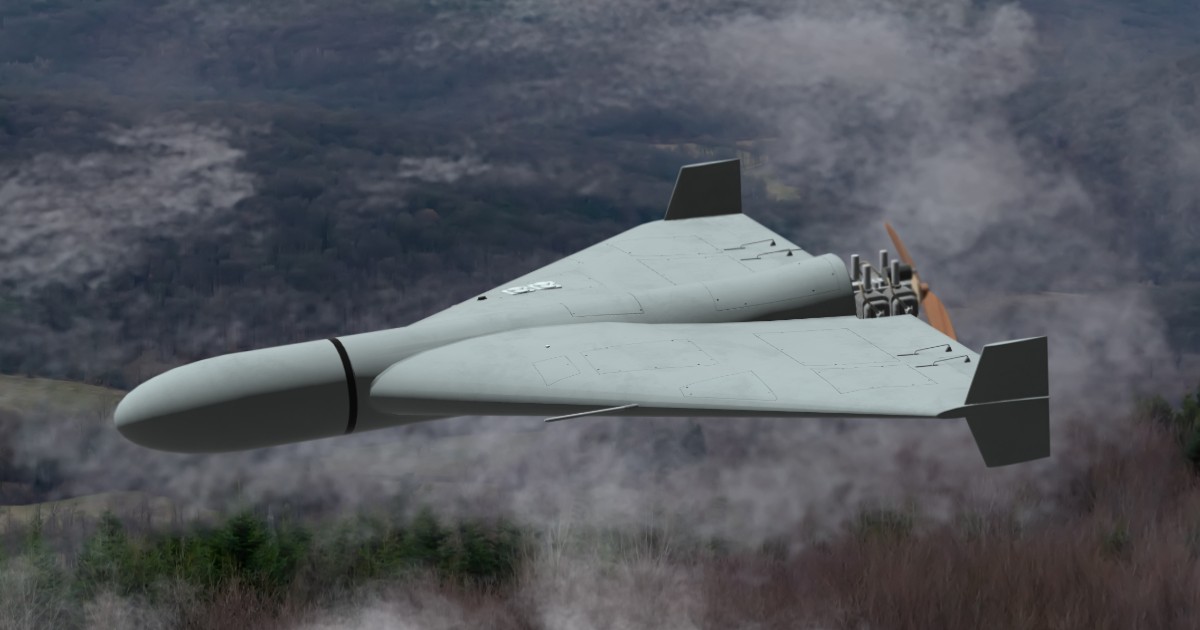 Imaginea prezintă o dronă militară zburând la joasă înălțime deasupra unui teren muntos acoperit de păduri și nori joși.
