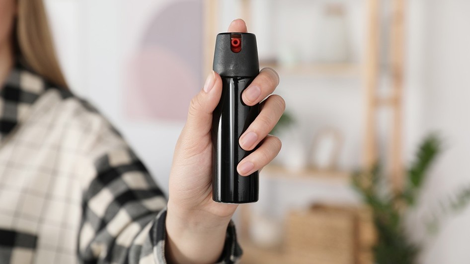O femeie care ține în mână un spray cu piper