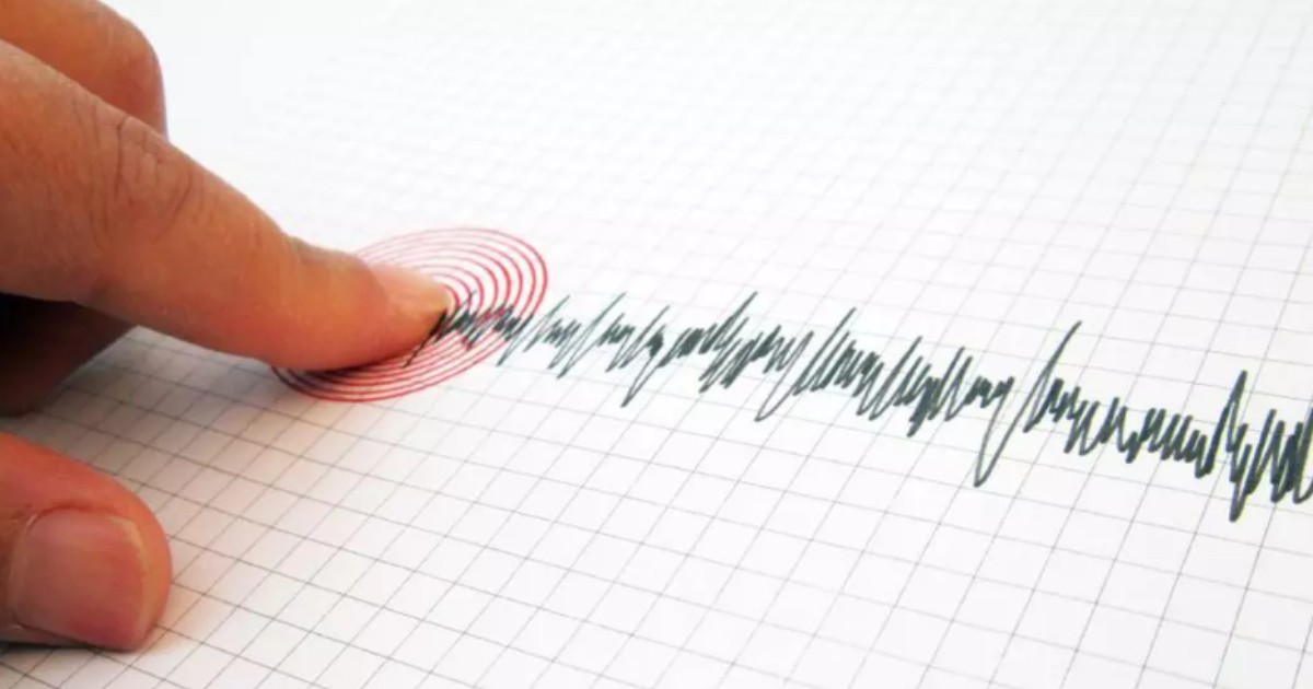 Imaginea arată un deget care atinge o foaie de hârtie pătrată pe care este trasată o linie cu înregistrările unui seismograf — instrument folosit pentru a detecta și înregistra cutremurele.
