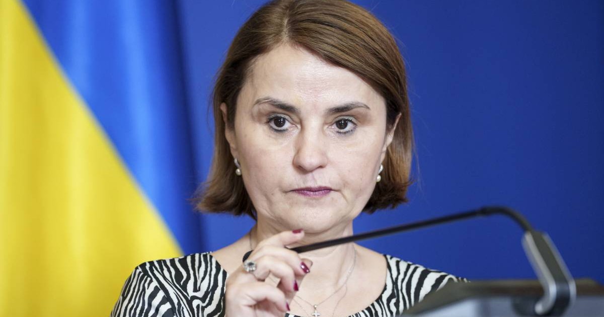 Luminița Odobescu, în timp ce vorbește la microfon, la o conferință de presă. Poartă o bluză în dungi și are părul tuns bob,