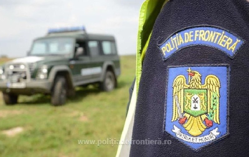 Insigna de la Poliția de Frontieră, in zare se vede o masina de la politia de frontiera