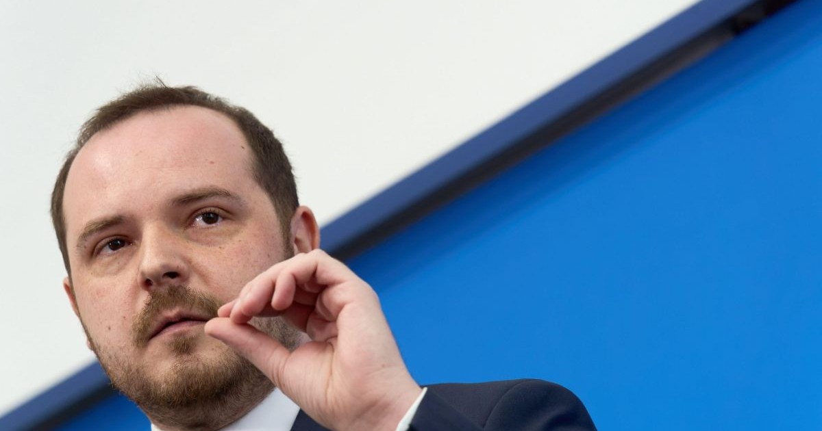 Alexandru Rogobete vorbește în cadrul unei conferințe de presă, arătând cu degetele de la mâna stângă nivelul de subfinanțare în care se află sănătatea, 24 aprile 2026
