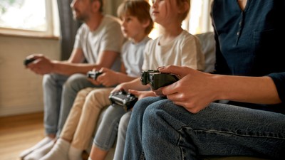 Close up of family with kids play video game online