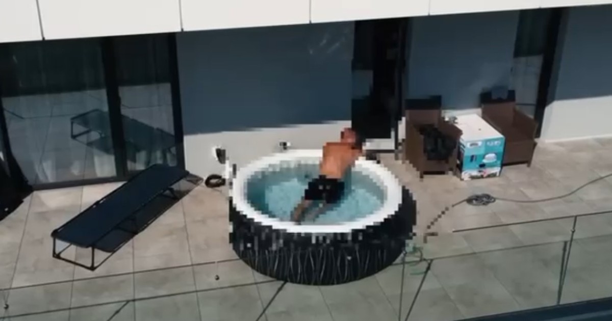 În imagine este surprins un bărbat aflat într-o piscină gonflabilă rotundă amplasată pe terasa unui apartament.