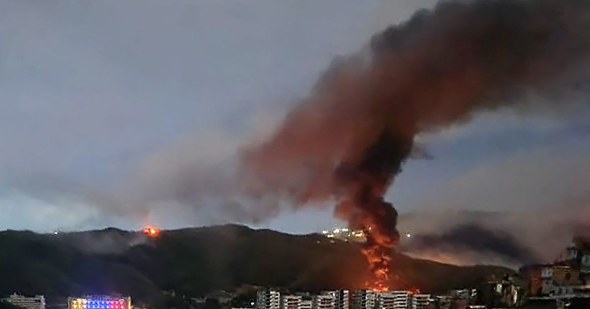 Incendiul de la Fuerte Tiuna, cel mai mare complex militar din Venezuela, este văzut de la distanță după o serie de explozii din Caracas, pe 3 ianuarie 2026