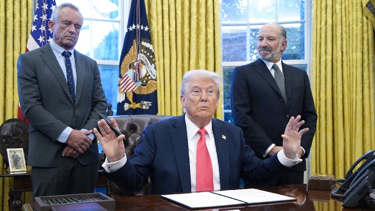 Președintele american Donald Trump vorbește cu reporterii alături de secretarul HSS Robert F. Kennedy Jr. și de secretarul nominalizat pentru Comerț Howard Lutnick (R) în Biroul Oval al Casei Albe din Washington la 25 februarie 2025.
