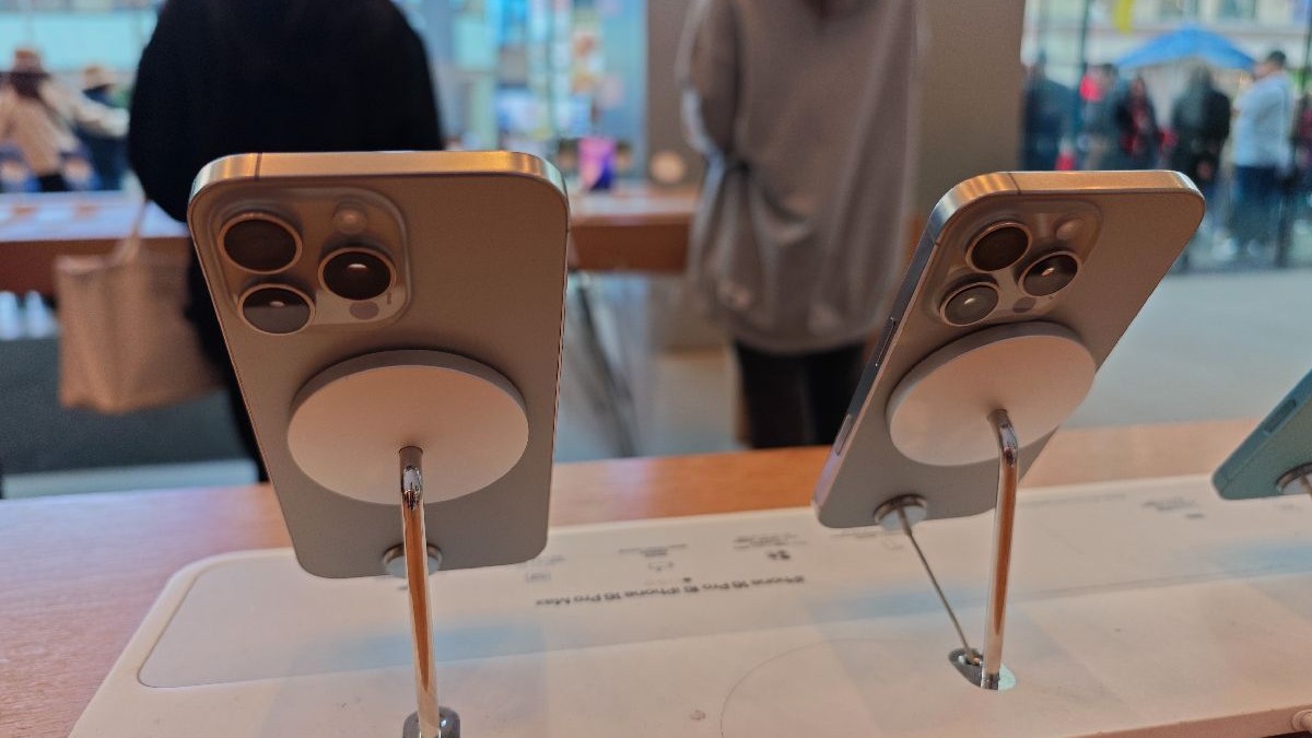 Două telefoane gri din seria iPhone 16 sunt așezate pe standuri de prezentare într-un magazin Apple din Shanghai, China.