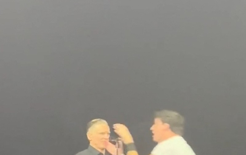 Momentul în care un fan sare pe scenă în timpul concertului lui Bryan Adams, îi smulge microfonul și începe să cânte. Reacția artistului