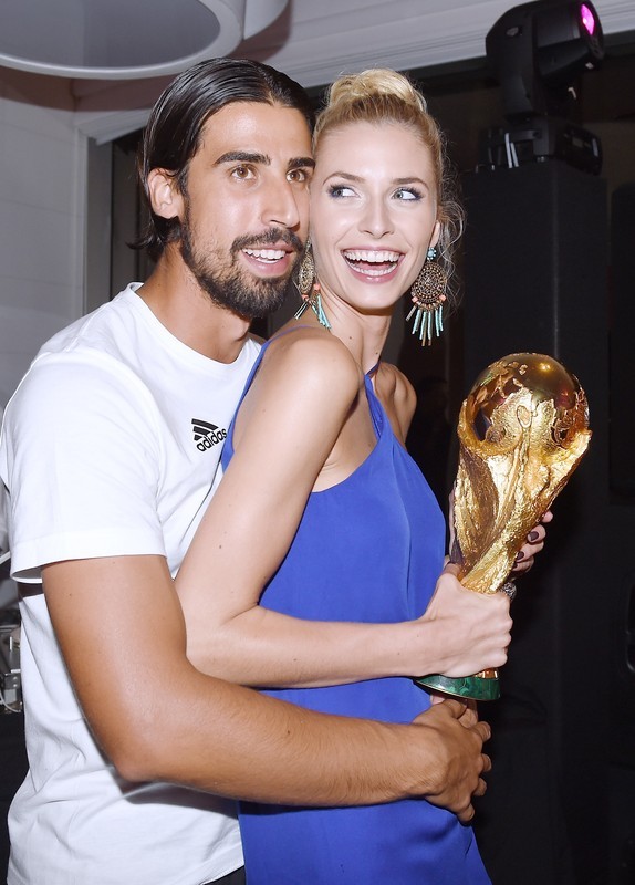 epa04315331 A handout photo released by the DFB (German Soccer Association) on 14 July 2014 shows Sami Khedira (L) and girlfriend Lena Gercke celebrating Germany's victory over Argentina in the Soccer World Cup 2014 with the trophy in Rio De Janeiro, Brazil, 13 July 2014. Germany won the World Cup after defeating Argentina 1-0. EPA/MARKUS GILLIAR / DFB / HANDOUT HANDOUT EDITORIAL USE ONLY/NO SALES