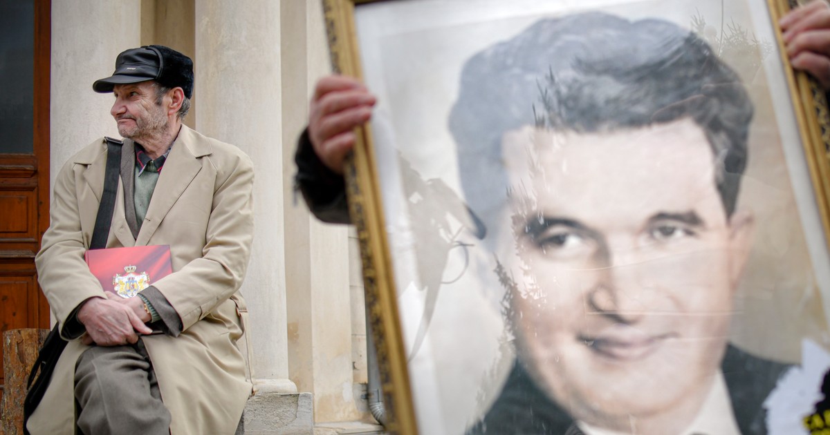 Un barbat sta langa un portret cu Nicolae Ceausescu, in timpul comemorarii a 30 de ani de la moartea cuplului Elena si Nicolae Ceausescu, in cimitirul Ghencea Civil din Bucuresti, miercuri, 25 decembrie 2019. Cuplul dictatorial Elena si Nicolae Ceausescu a fost executat in 25 decembrie 1989, la o cazarma din Targoviste, in urma unui proces, in care cei doi au fost acuzati de genocid. Sentinta data a fost condamnarea la moarte. ANDREEA ALEXANDRU / MEDIAFAX FOTO