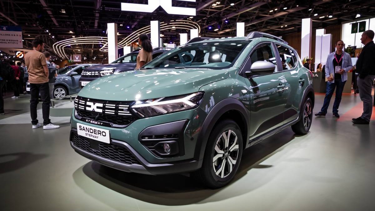 dacia sandero intr-un showroom, in jurul masinii sunt mai multi oameni care studiaza modelul