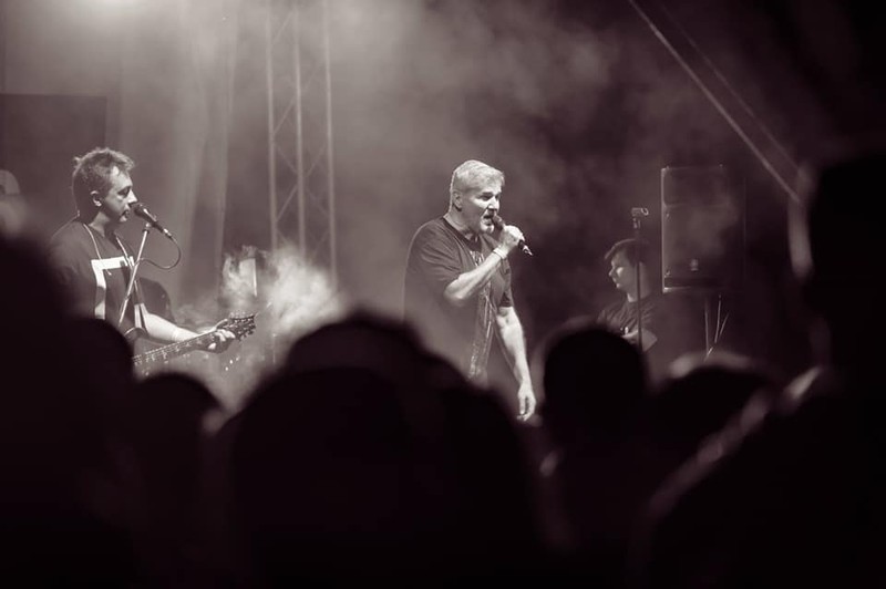 Trupa Holograf donează banii primiți pentru spectacolul din Sectorul 5. Fotografie alb-negru din timpul unui concert al trupei Holograf, cu Dan Bittman la microfon