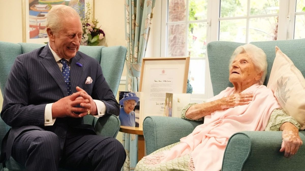 Ethel Caterham, o femeie de 116 ani, considerată în prezent cea mai bătrână femeie din lume, în dreapta, asezată in fotoliu , alături de Regele Charles, in costum inchis la culoare, in stanga, asezat in fotoliu, surprins in timp ce rade, septembrie 2025