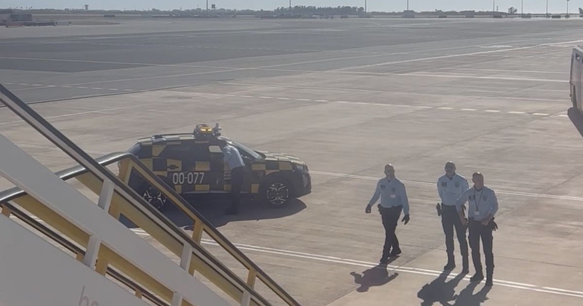 O echipă de poliție așteaptă pe pista de aeroport debarcarea călătorilor dintr-un avion care vine din Portugalia, Marrakech, Maroc, 29 mai 2025