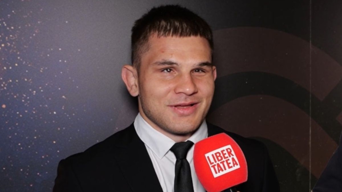 Alexandru Bologa, îmbrăcat cu un costum negru, cămașă albă și cravată neagră, cu microfonul Libertatea în față, la Gala Sportului Paralimpic 2026