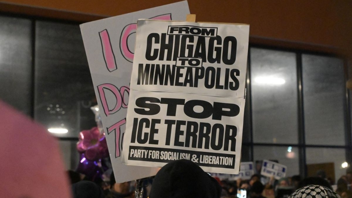 Un manifestant ține un pancart pe care scrie „De la Chicago la Minneapolis, opriți teroarea ICE” în timpul unei veghe de urgență și a unui protest în cartierul Little Village, pe 7 ianuarie 2026, în Chicago, Illinois. Organizată de Consiliul Comunității Little Village și de activiști locali, adunarea a avut loc ca răspuns la împușcarea mortală a lui Renee Nicole Good, o cetățeană americană în vârstă de 37 de ani.