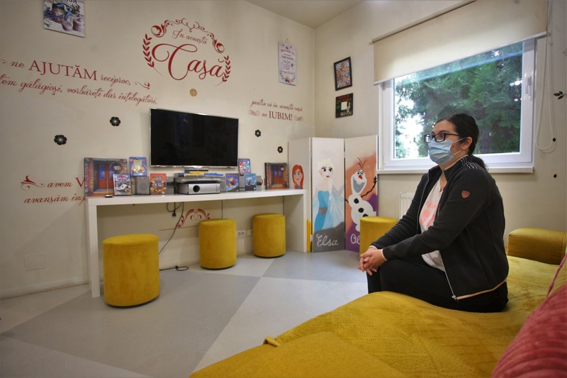 Adriana stă în sufrageria comună a casei Ronald McDonald