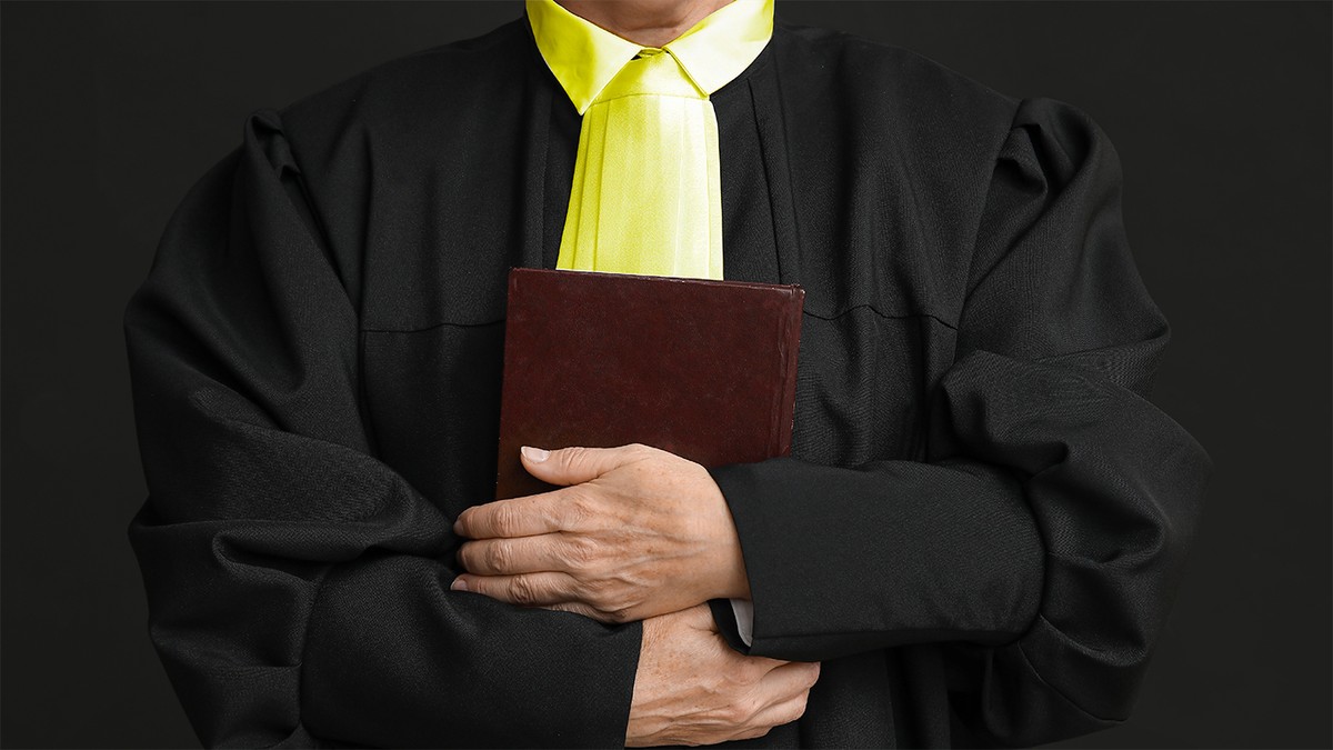 Un avocat cu roba neagra si esarfa aurie