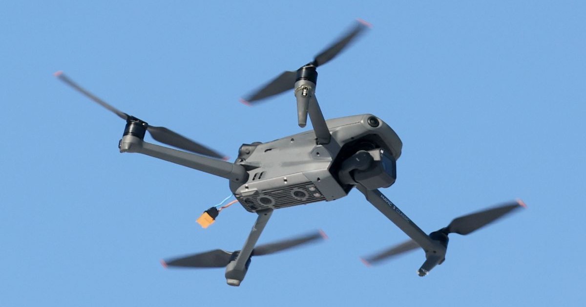 O dronă militară zboară pe fundalul unui cer albastru și senin