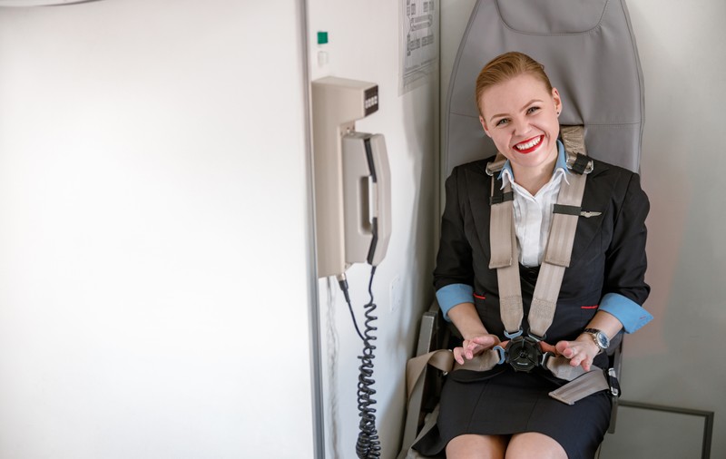 De ce stau stewardesele cu mâinile sub coapse la decolarea și aterizarea avionului