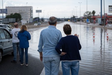 Câteva persoane privesc o secțiune inundată a autostrăzii de est, A-3, pe 12 noiembrie 2022, în Valencia. | Foto: Profimedia