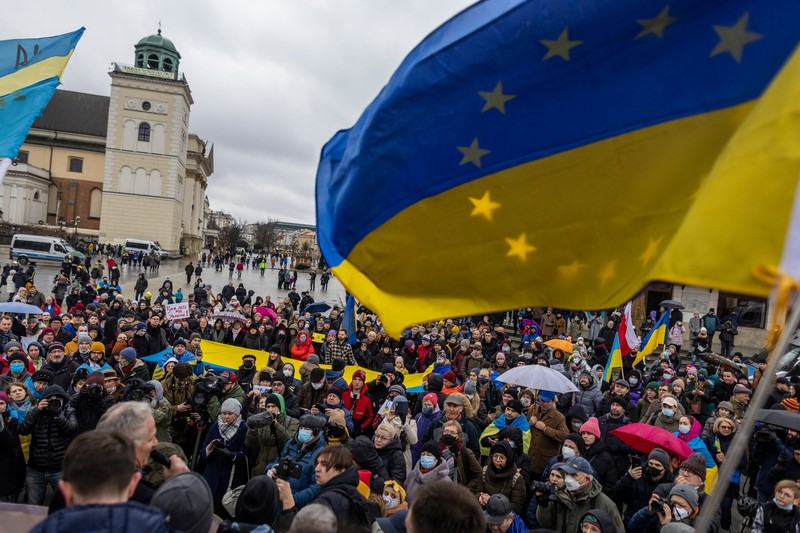 Protestatarii flutură steaguri ucrainene în timpul unei demonstrații pentru pacea din Ucraina, la Varșovia, pe 20 februarie. | Foto: Profimedia