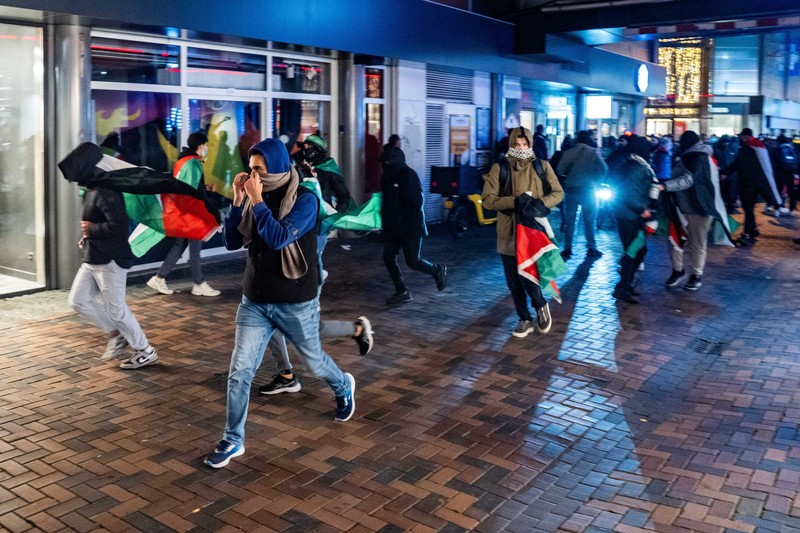 07 November 2024, Netherlands, Amsterdam: Protesters run with Palestinian flags during a pro-Palestinian demonstration at Anton de Komplein during the UEFA Europa League soccer match between Ajax Amsterdam and Maccabi Tel Aviv. The demonstration was originally planned at the Johan Cruijff Arena, but was banned by the city council. Photo: Jeroen Jumelet/ANP/dpa