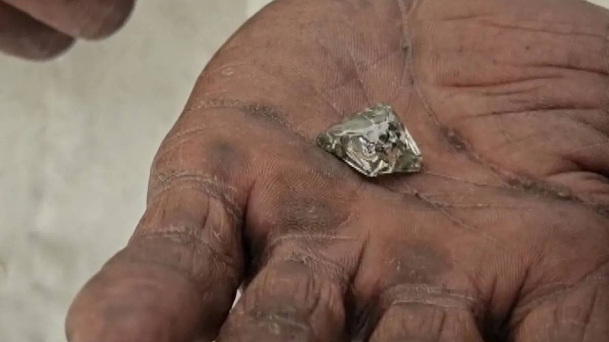 Mâna murdara a unui bărbat care tine un diamant de 17,96 carate descoperit in India