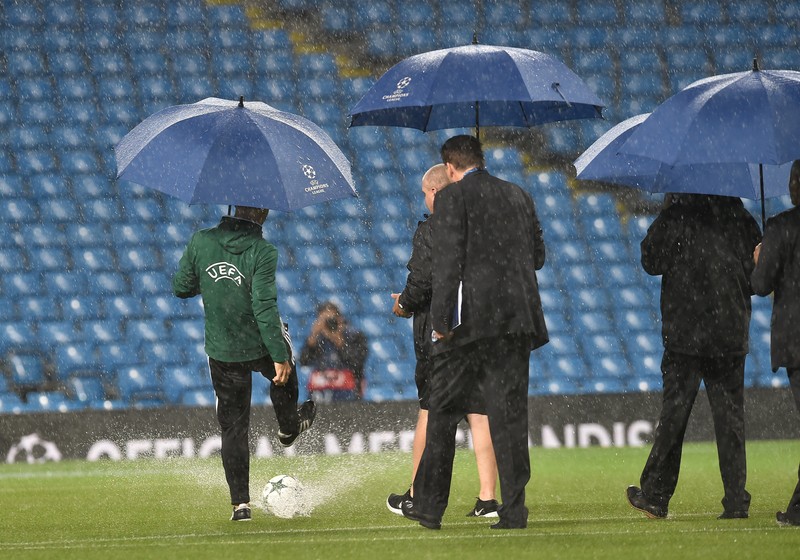 epa05538190 An UEFA official kicks a ball on the pitch as heavy rain falls before the UEFA Champions League Group C match between Manchester City and Borussia Monchengladbach held at the Etihad Stadium in Manchester, Britain, 13 September 2016. EPA/PETER POWELL