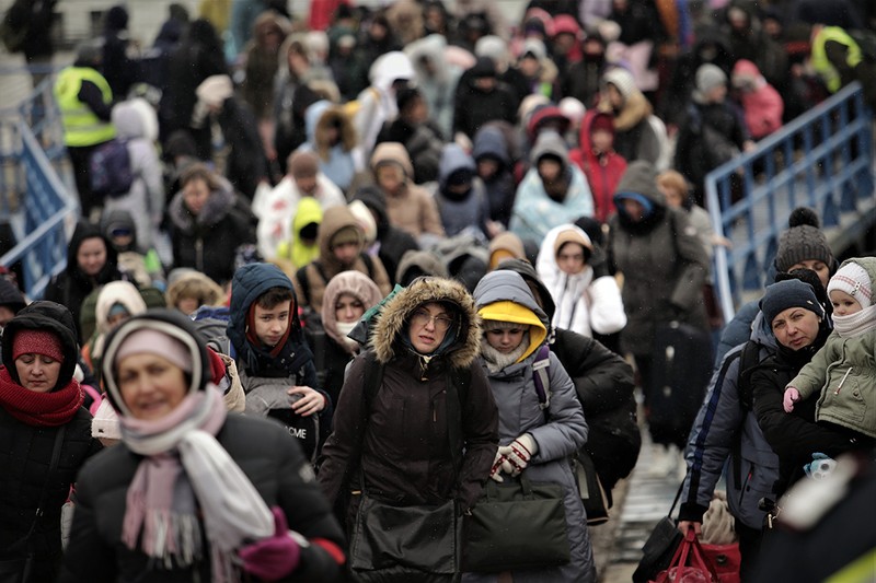 Pentru a rezista ore întregi în ger, refugiaţii poartă mai multe rânduri de haine