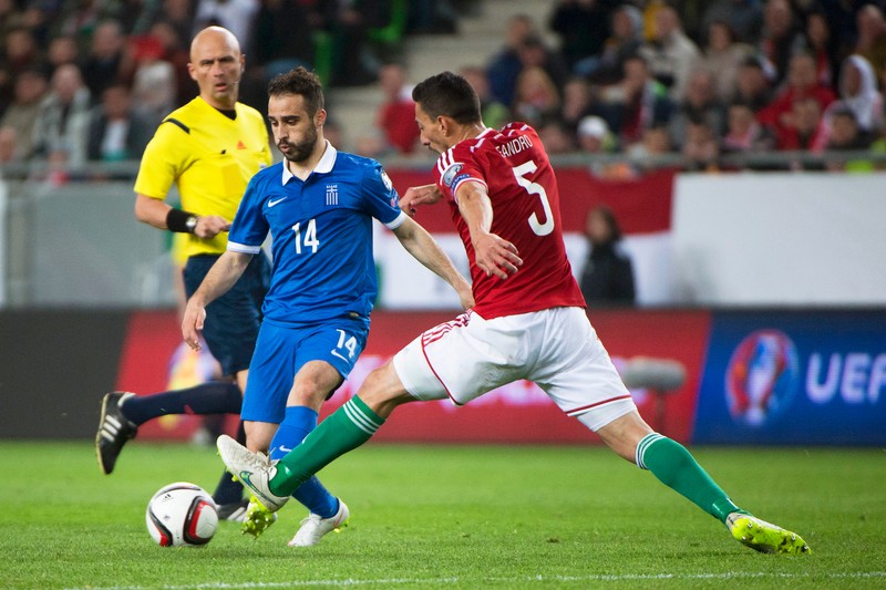 epa04686070 Leandro (R) of Hungary in action against Giannis Fetfatzidis (C) of Greece during the UEFA EURO 2016 qualifying Group F soccer match between Hungary and Greece at the Groupama Arena in Budapest, Hungary, 29 March 2015. EPA/SZILARD KOSZTICSAK HUNGARY OUT