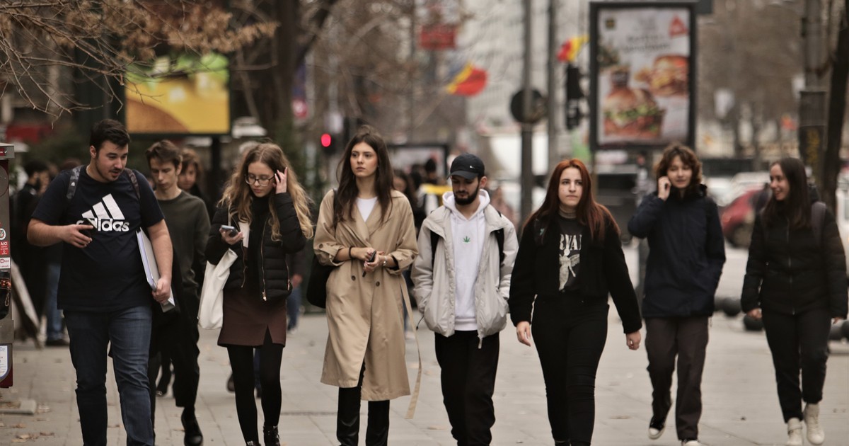 Grup de tineri merg pe strada in Bucuresti, Romania