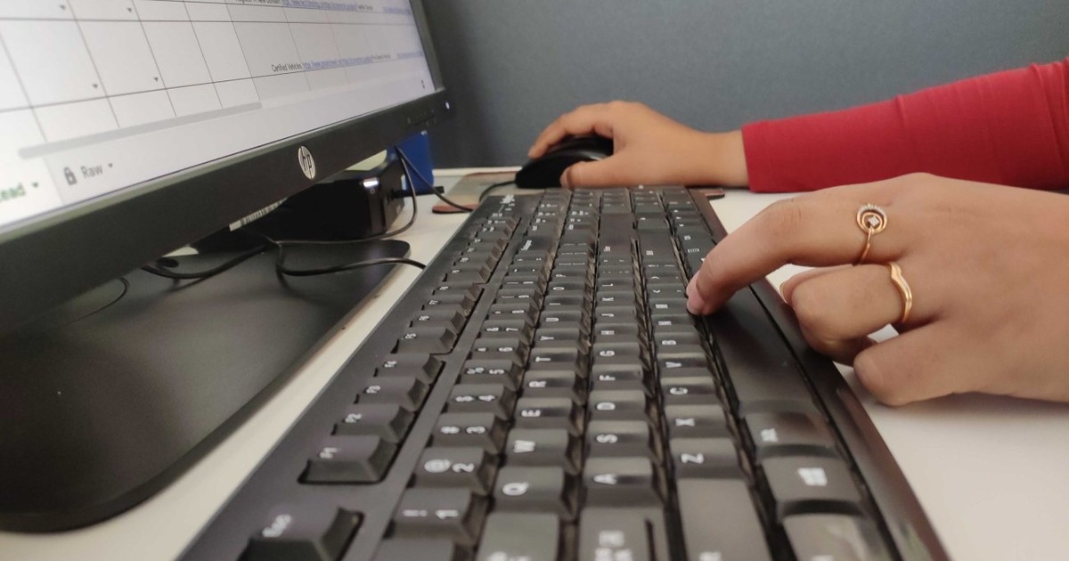 Fotografie ilustrativă cu un angajat care trimite un e-mail de pe un calculator