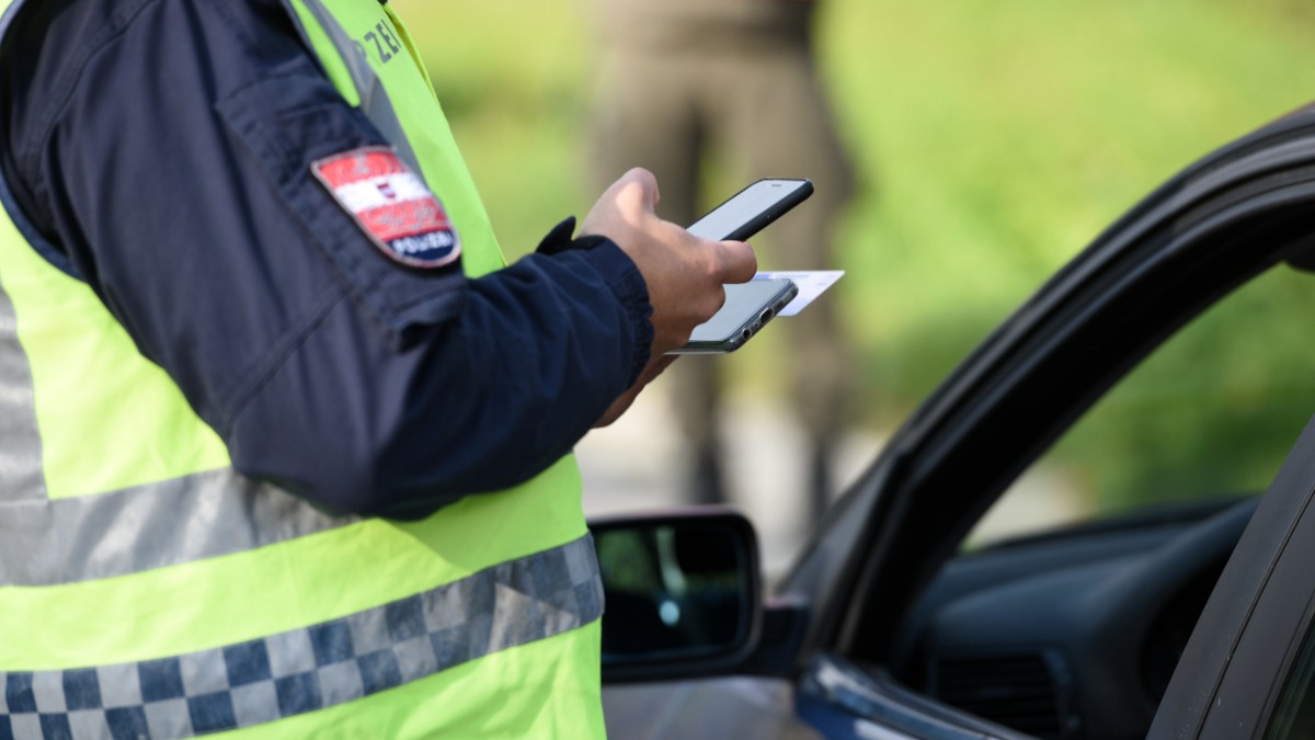 Un polițist care a oprit un șofer și verifică actele